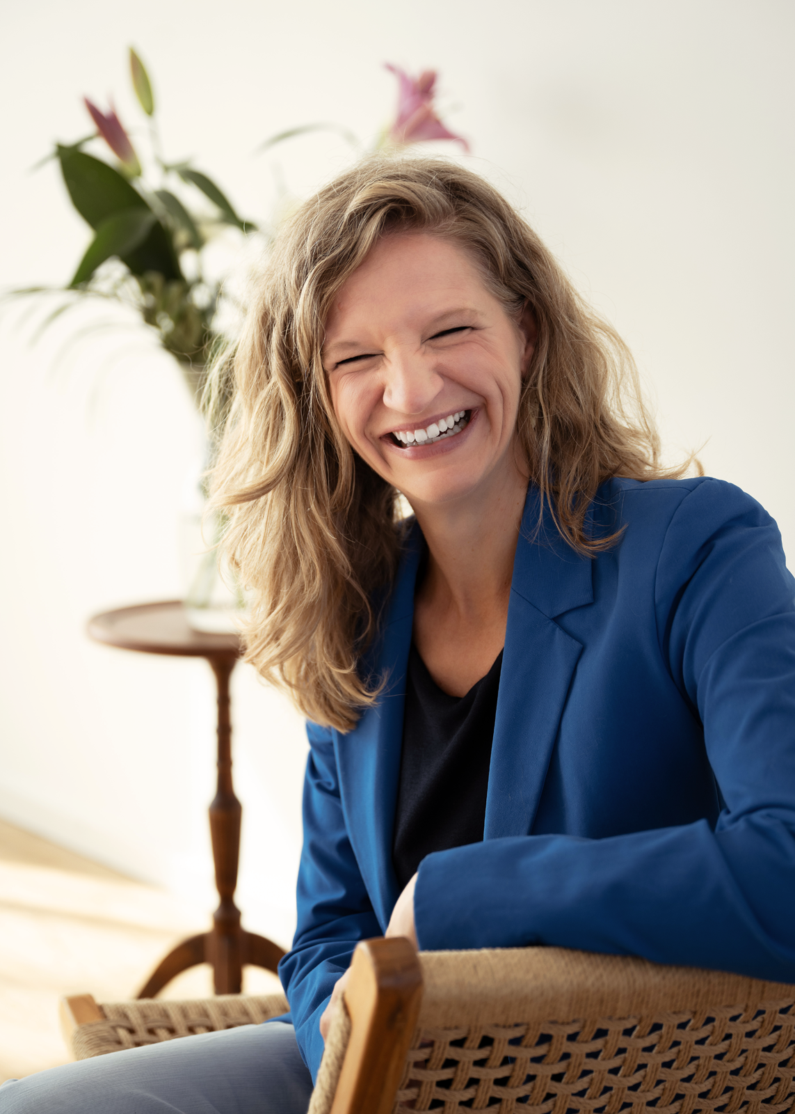 Claudia Höhberger lacht in die Kamera und trägt einen blauen Blazer.